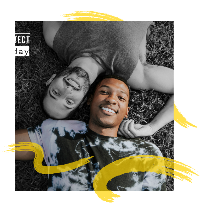 Here is an image of two men lying on the floor and smiling towards the camera. Image is symbolical of the fact that PrEP can lower the risk of HIV by 90%